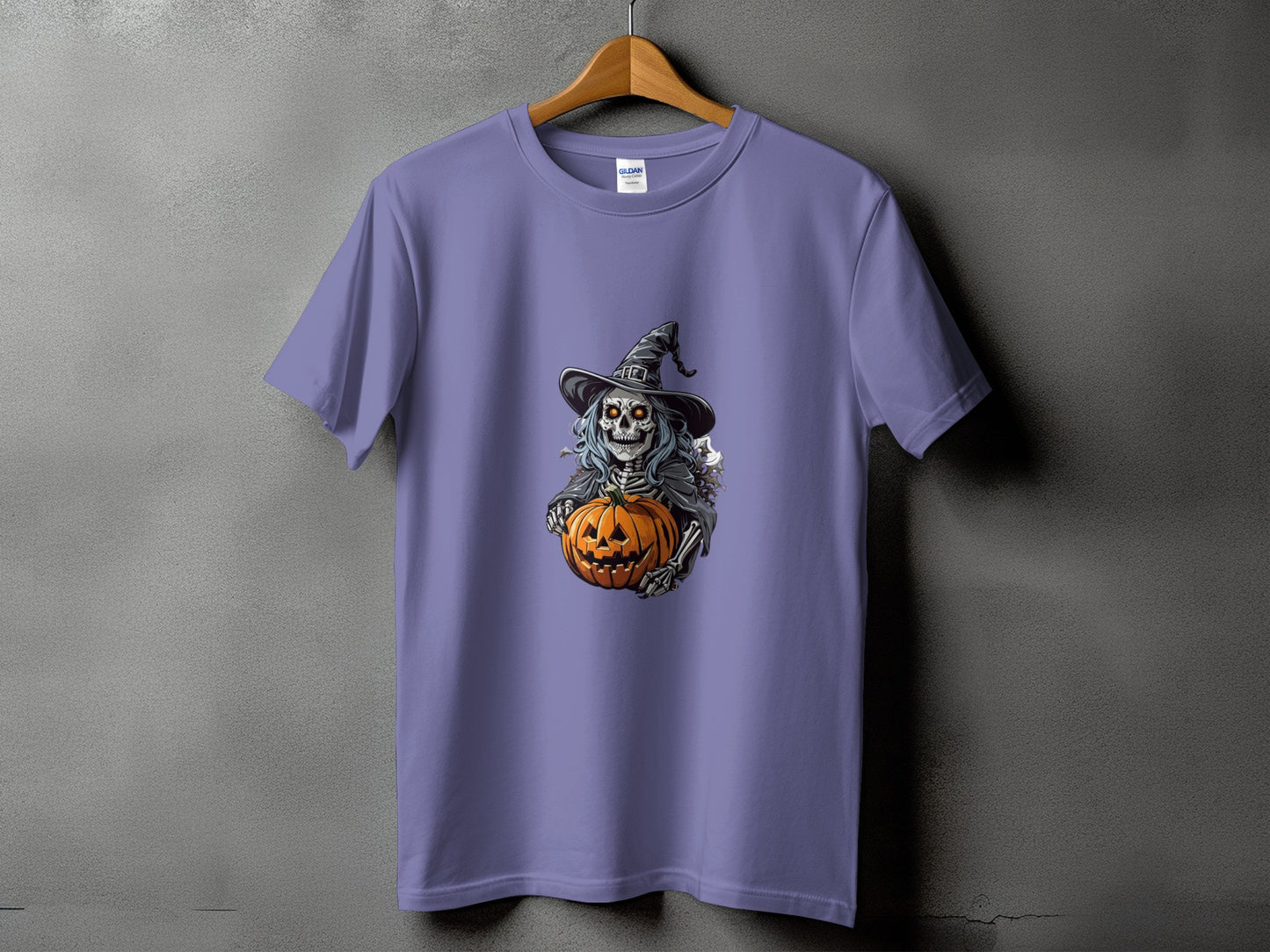 Skeleton wearing a witch hat holding a jack-o'-lantern on a lavender t-shirt.