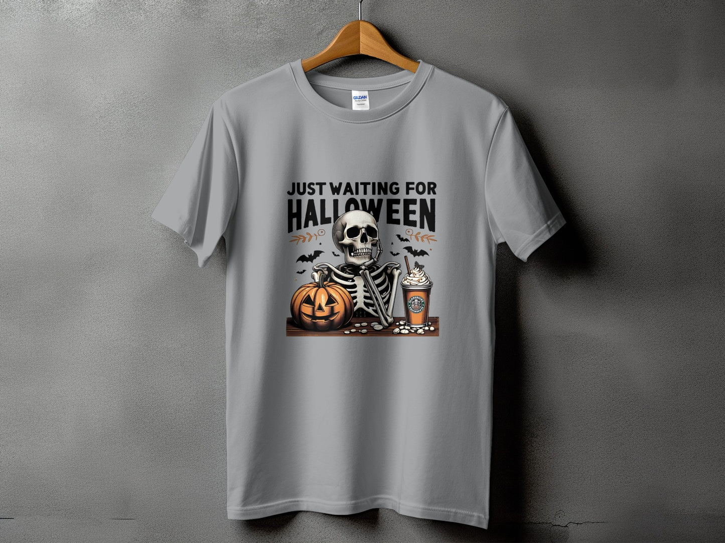 Gray t-shirt with skeleton, pumpkin, and coffee graphic and text "Just Waiting For Halloween".