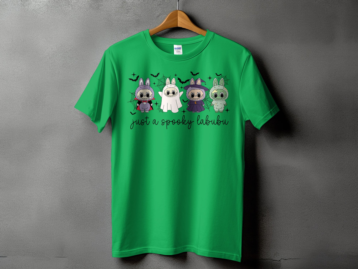 Green t-shirt with four Halloween-themed Labubu characters and text.