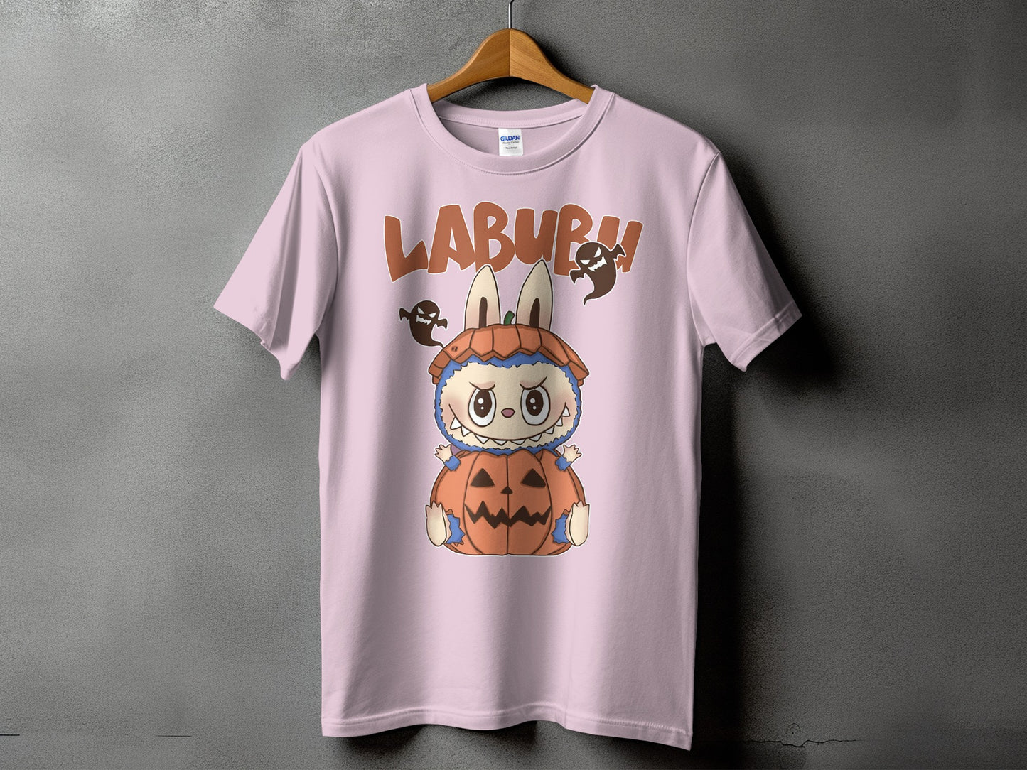 Pink t-shirt with "LABURU" text and a cute monster in a pumpkin costume.
