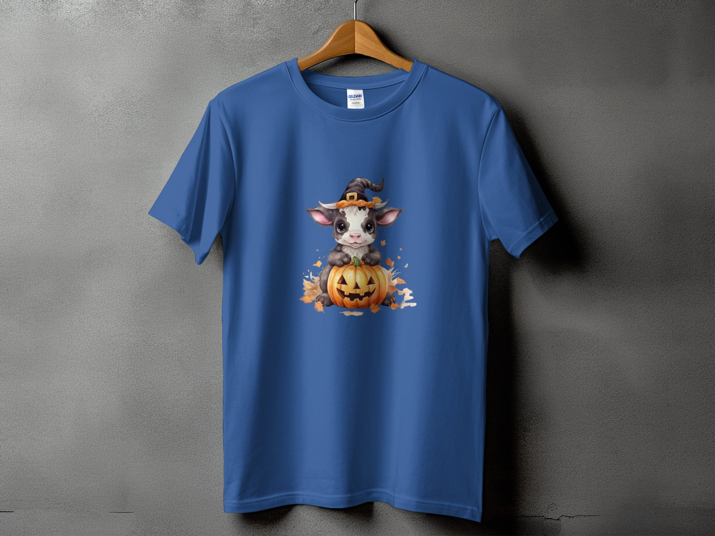 Blue t-shirt with a cute cow wearing a witch hat on a jack-o'-lantern.