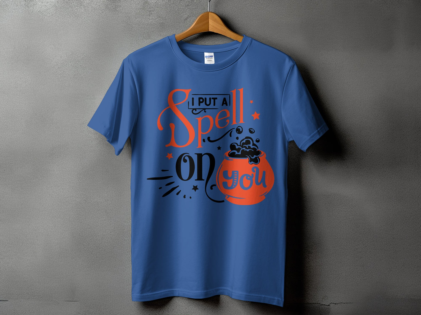 Blue t-shirt with text "I PUT A Spell ON YOU" and cauldron graphic.