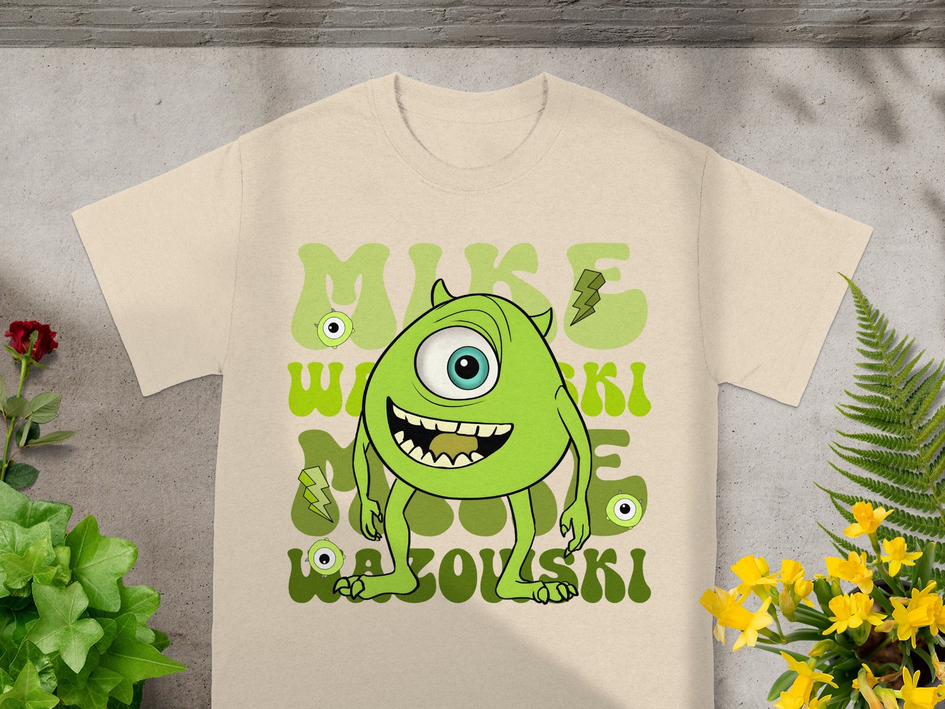 Mike Wazowski character on a beige t-shirt with green text.