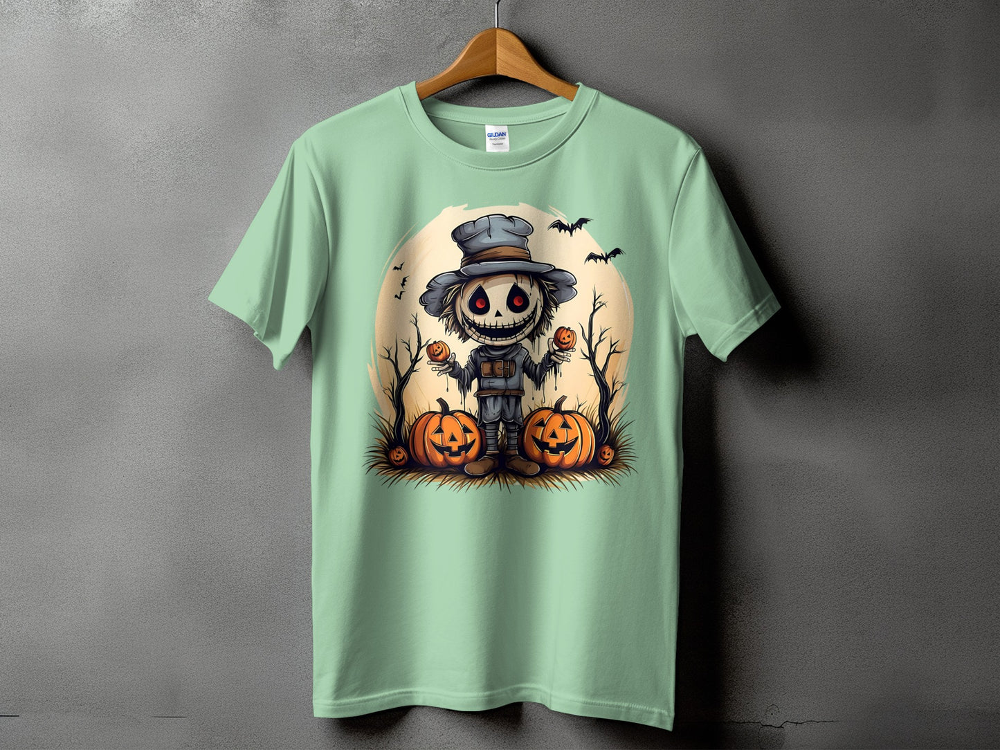 Light green t-shirt with a spooky scarecrow character and pumpkins Halloween graphic.
