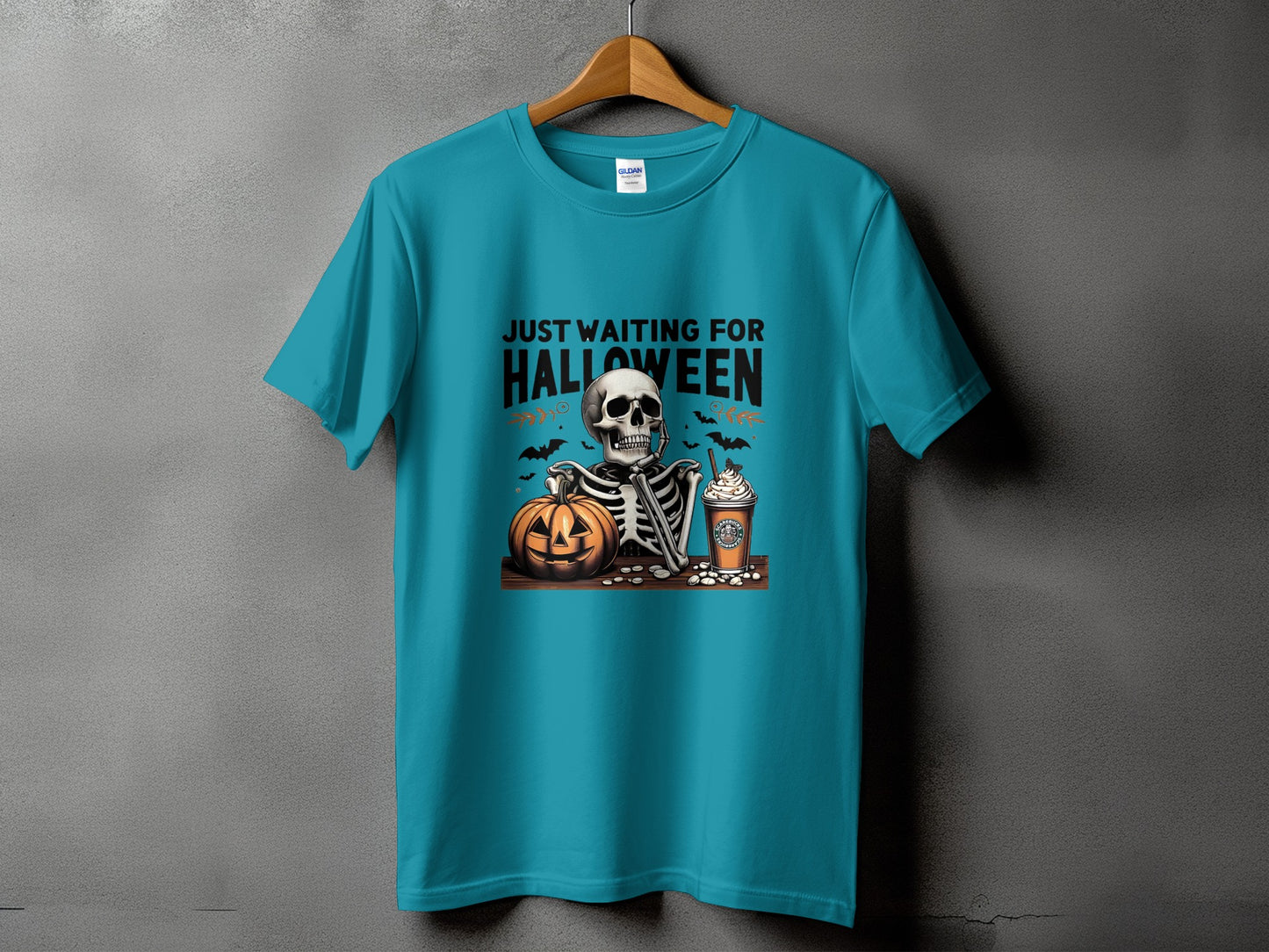 Teal t-shirt with skeleton, pumpkin, and coffee cup graphic reading "Just Waiting For Halloween."