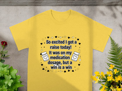 Yellow t-shirt with text "So excited I got a raise today! It was on my medication dosage, but a win is a win".