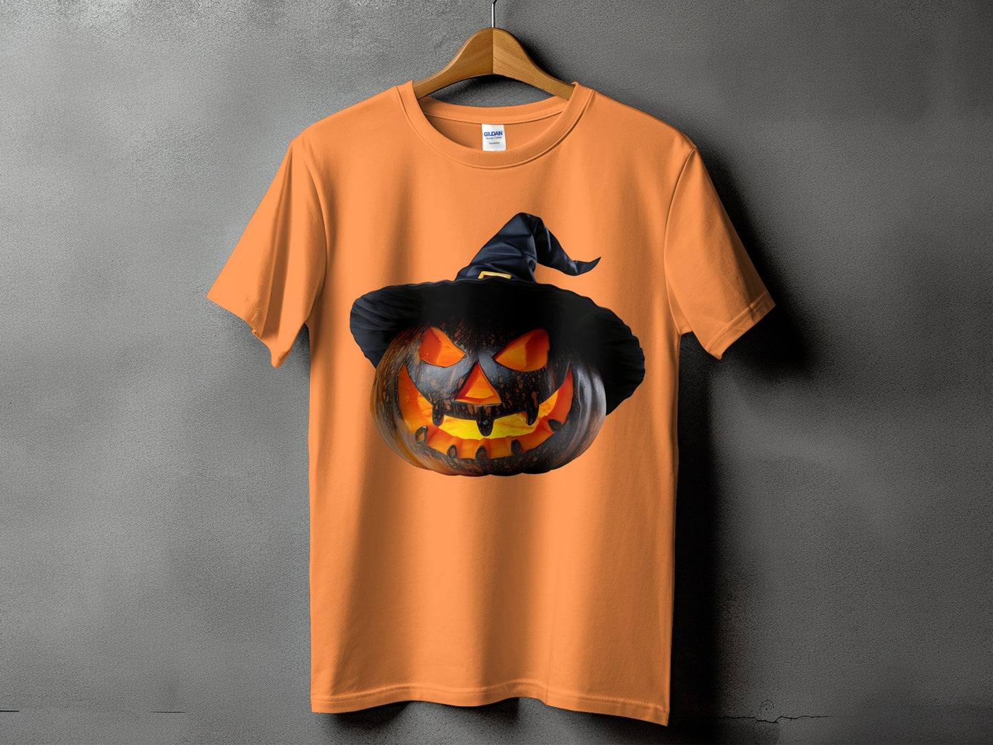 Orange t-shirt with a spooky jack-o'-lantern wearing a black witch hat graphic.