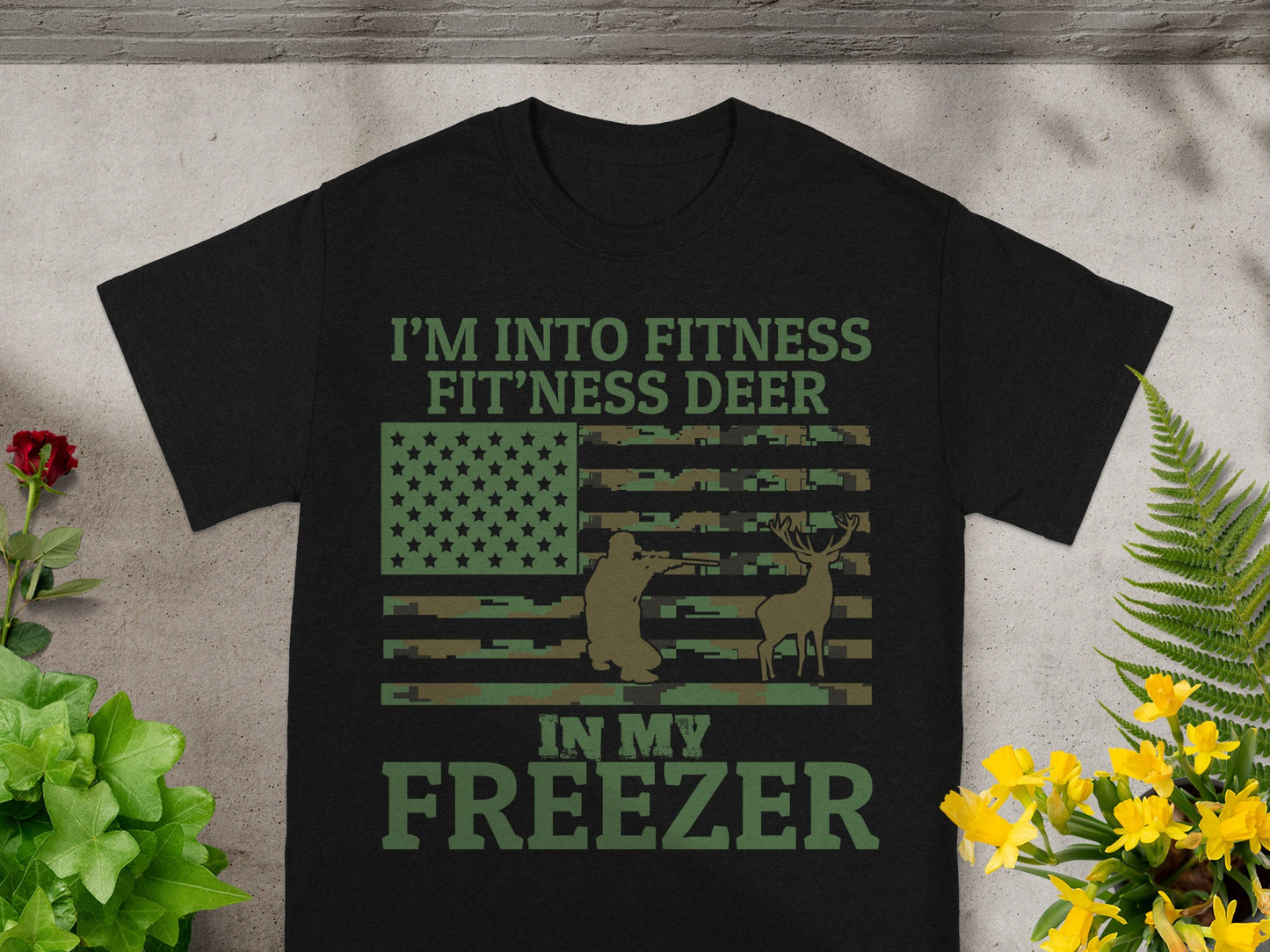 Black t-shirt with "I'm Into Fitness Fit'ness Deer In My Freezer" text and camouflage flag.