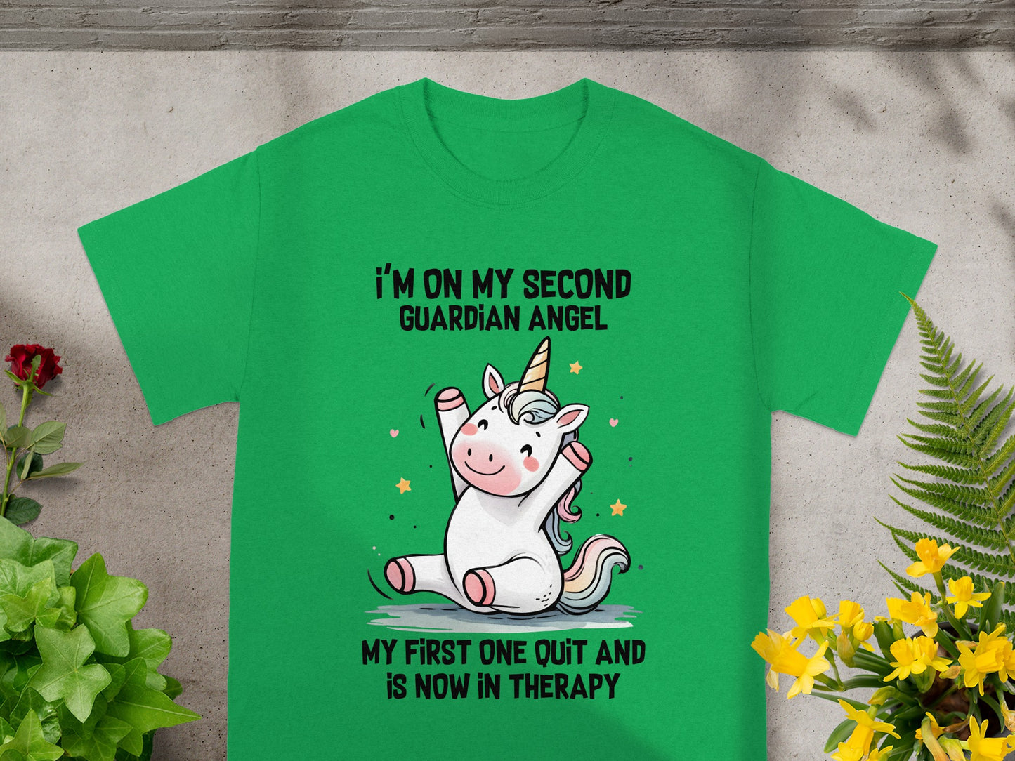 Green t-shirt with cartoon unicorn and text "I'm on my second guardian angel."