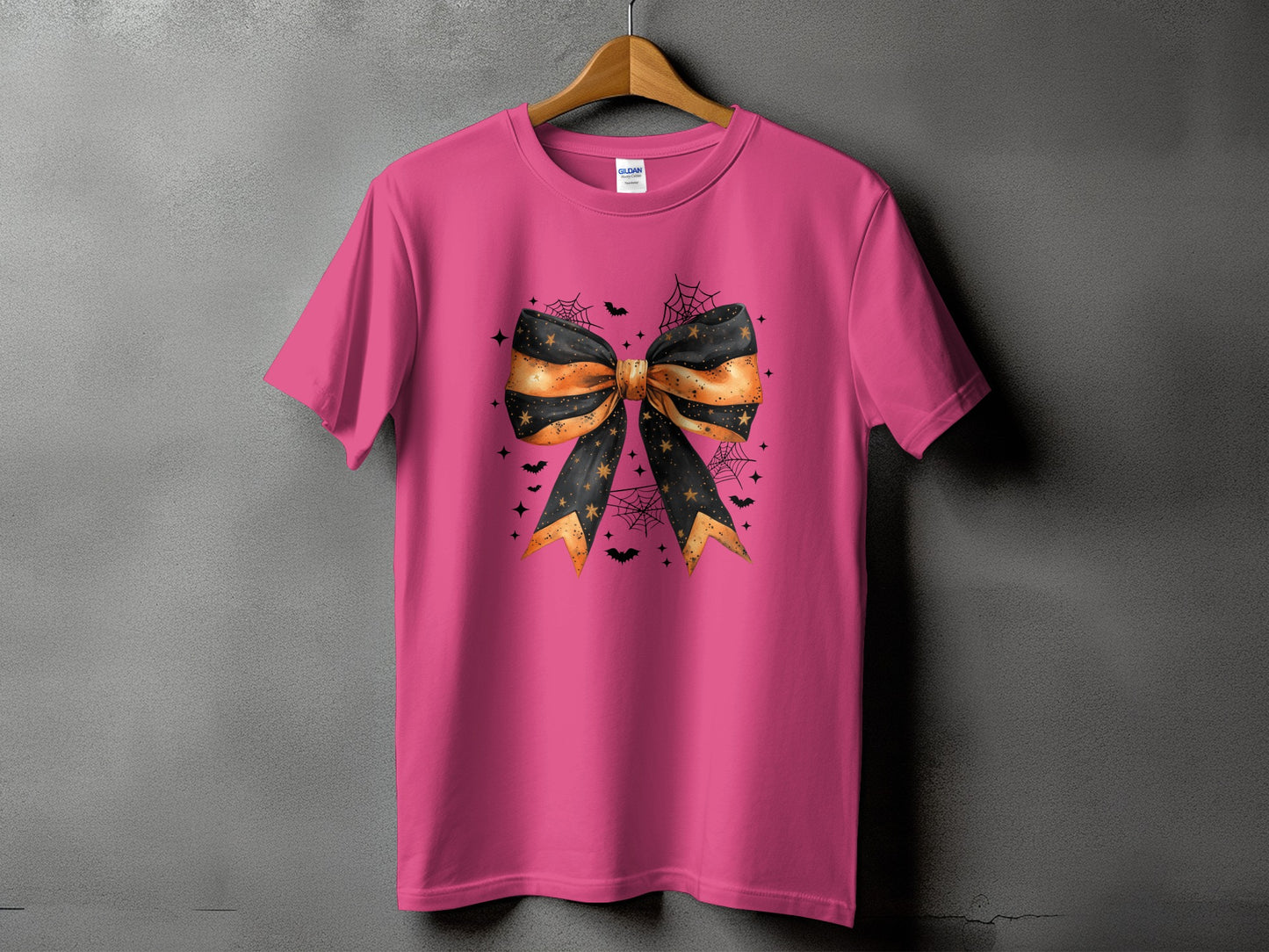 Pink t-shirt with Halloween-themed black and orange bow graphic and bats.