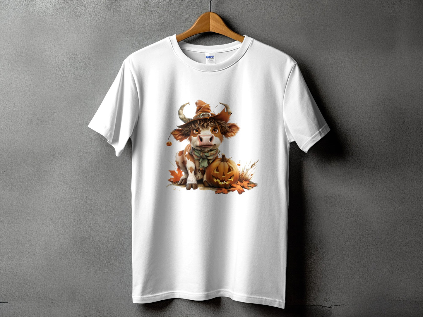 White t-shirt featuring a cute cow in a witch hat with a pumpkin.