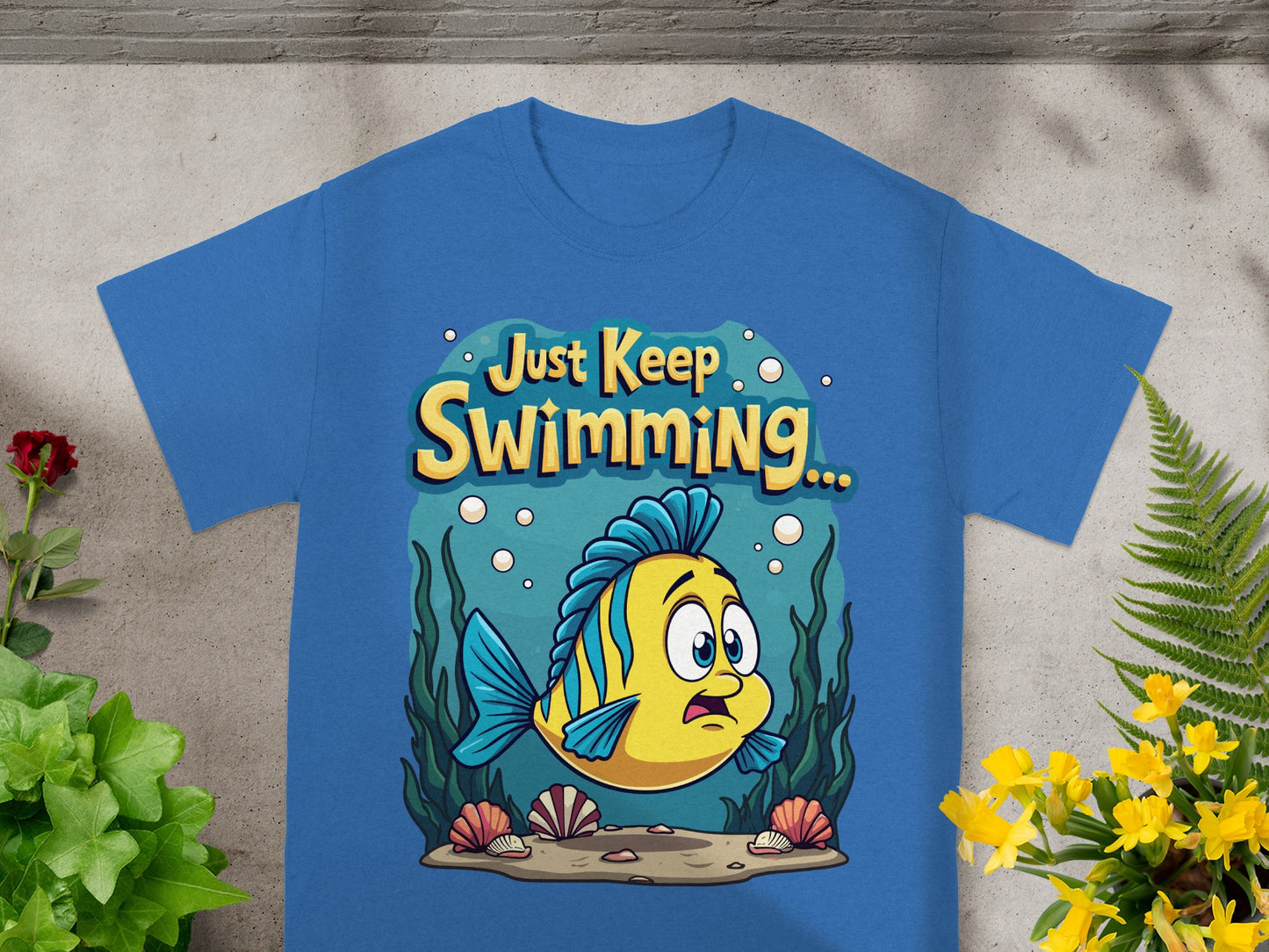 Blue t-shirt with cartoon yellow fish and text "Just Keep Swimming..."