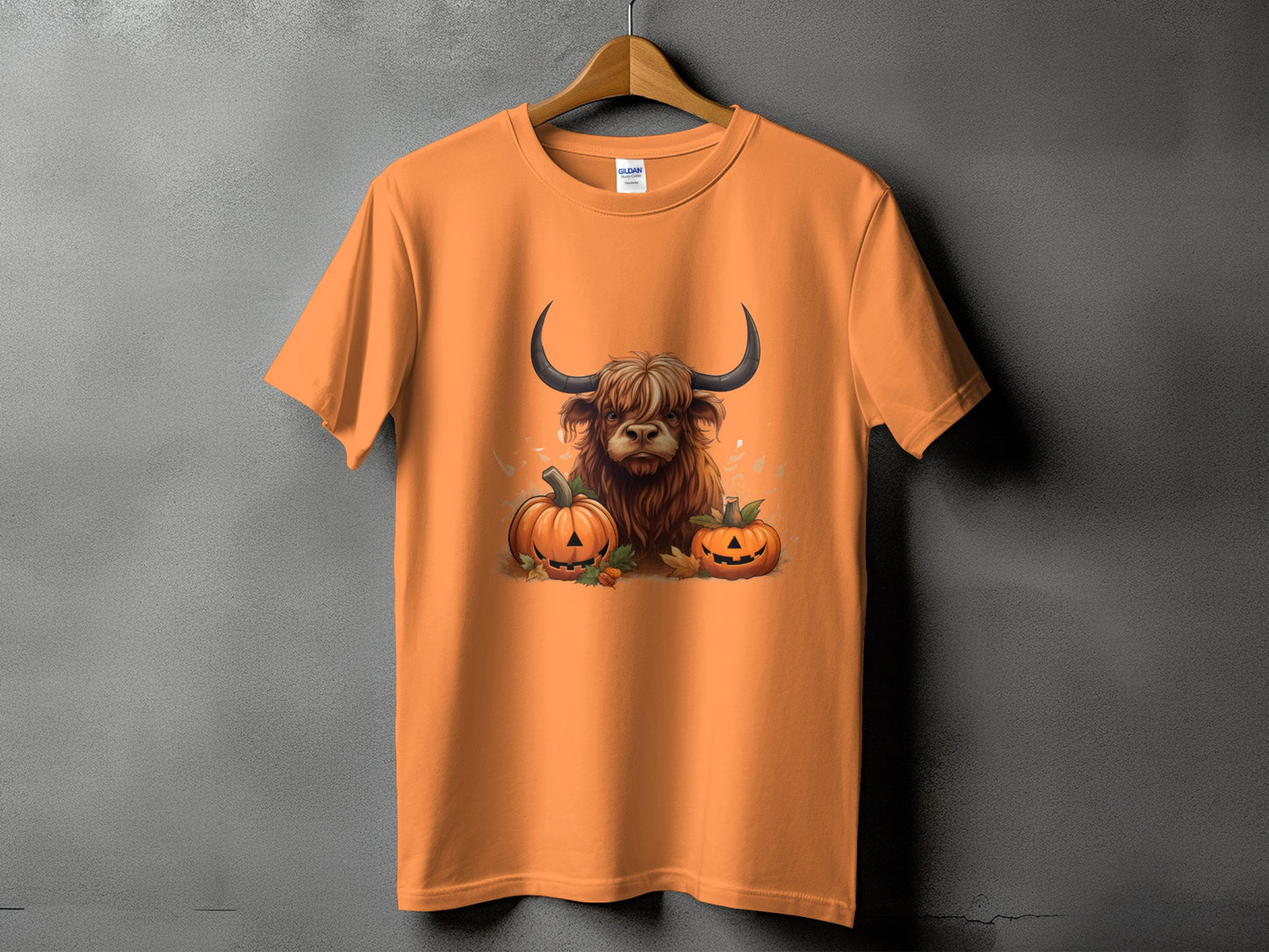 Orange t-shirt with a Highland cow and pumpkins graphic.