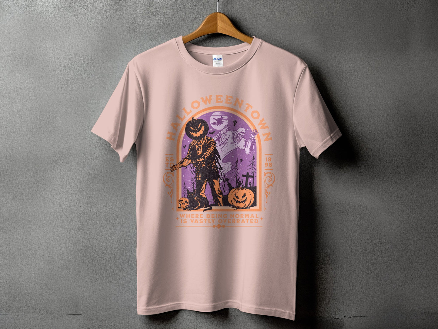 Pink t-shirt with "Halloweentown" graphic featuring a scarecrow, ghost, and pumpkins.