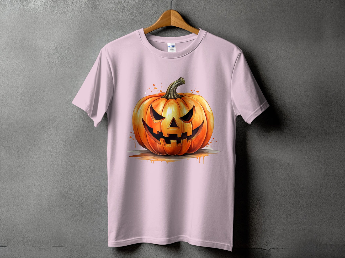 Pink t-shirt with a watercolor jack-o'-lantern graphic with dripping orange accents.
