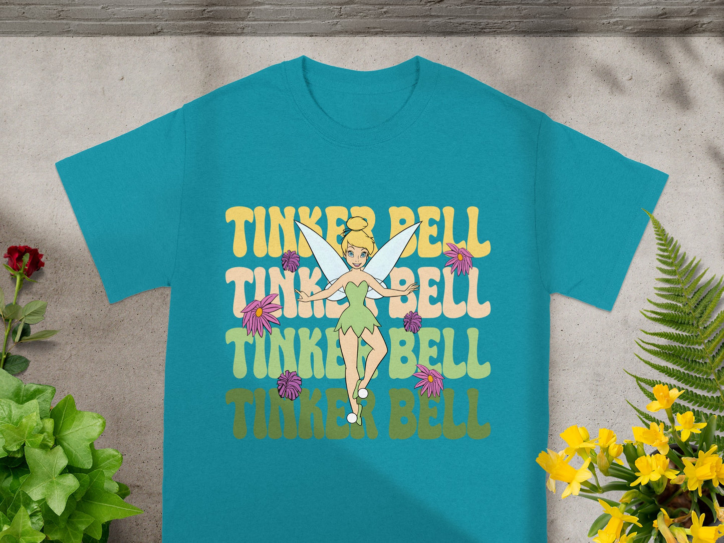 Tinkerbell graphic tee with floral accents and colorful text.