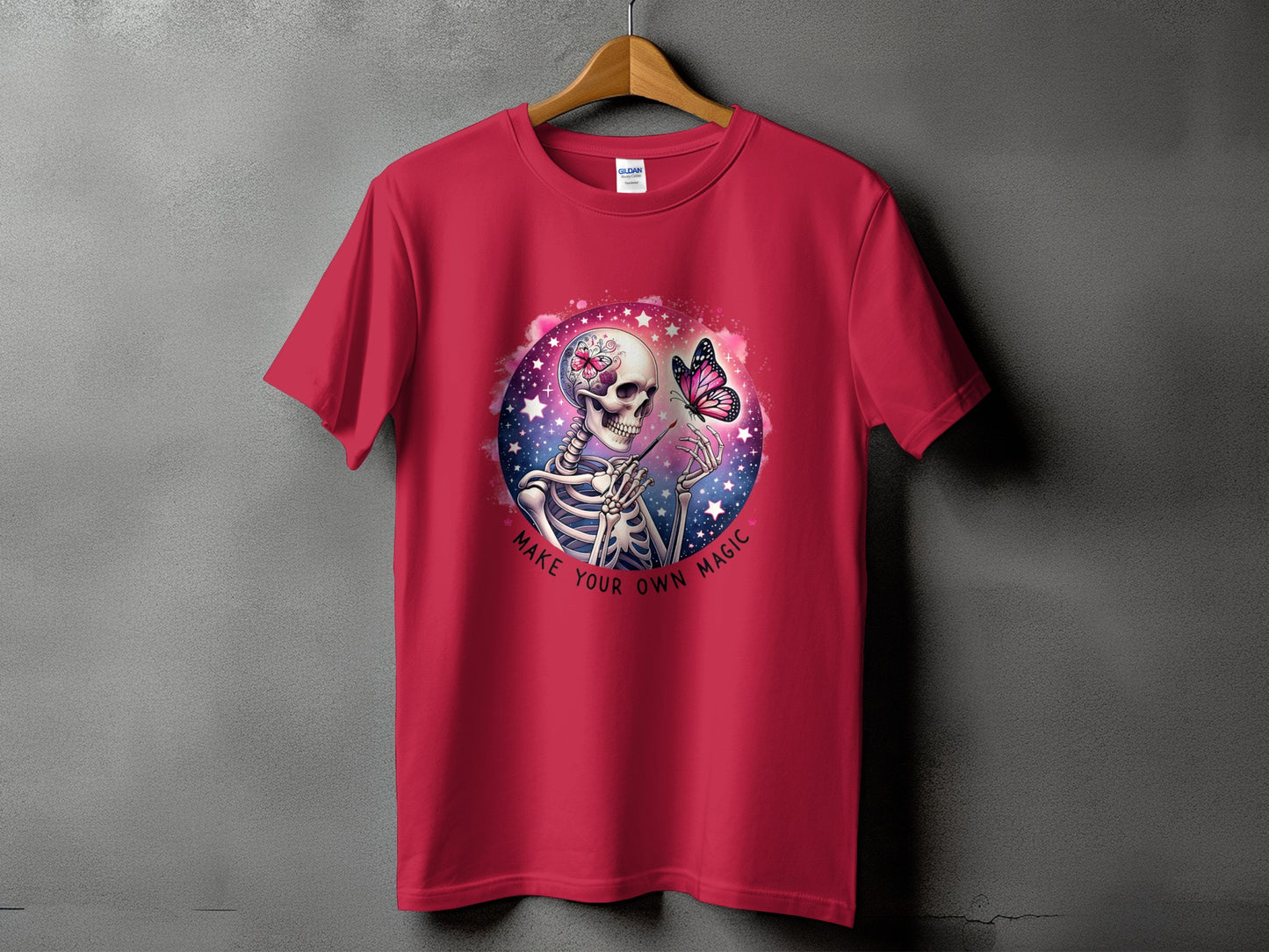 Crimson t-shirt with skeleton painting a butterfly, "Make Your Own Magic" text.