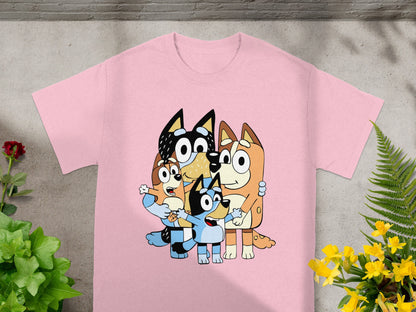 Bluey, Bingo, Bandit, and Chilli characters embrace on a pink t-shirt.