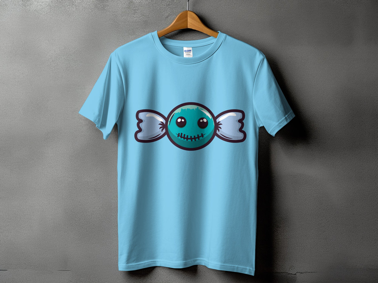 Light blue t-shirt with a graphic of a teal candy with a stitched smile.