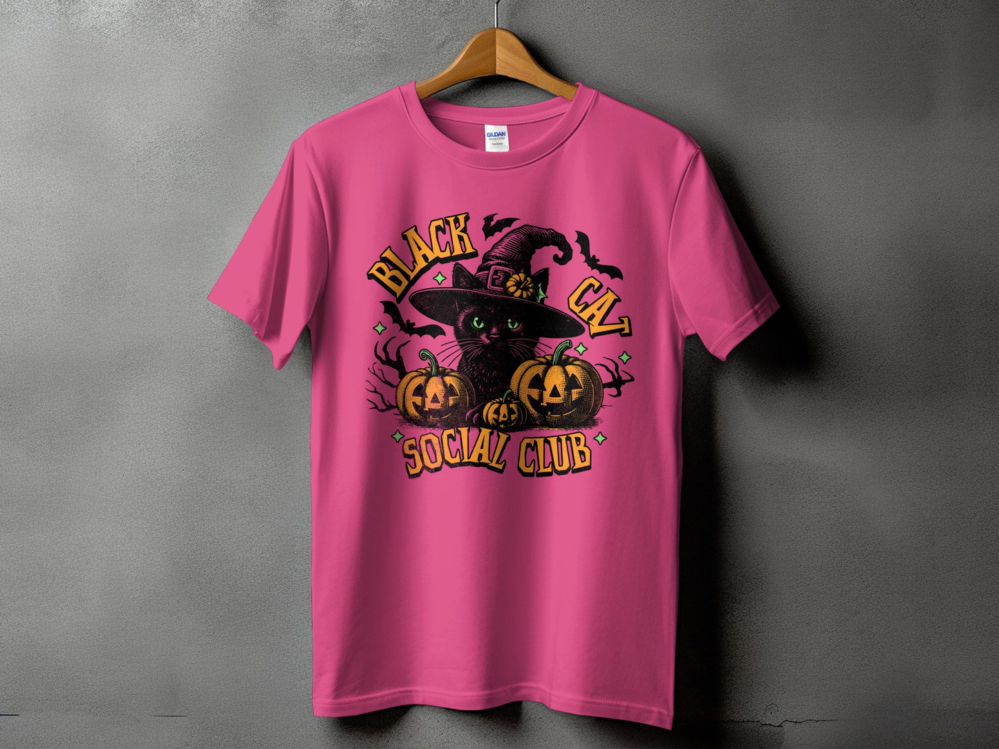 Pink t-shirt with Halloween graphic: black cat, pumpkins, and text.
