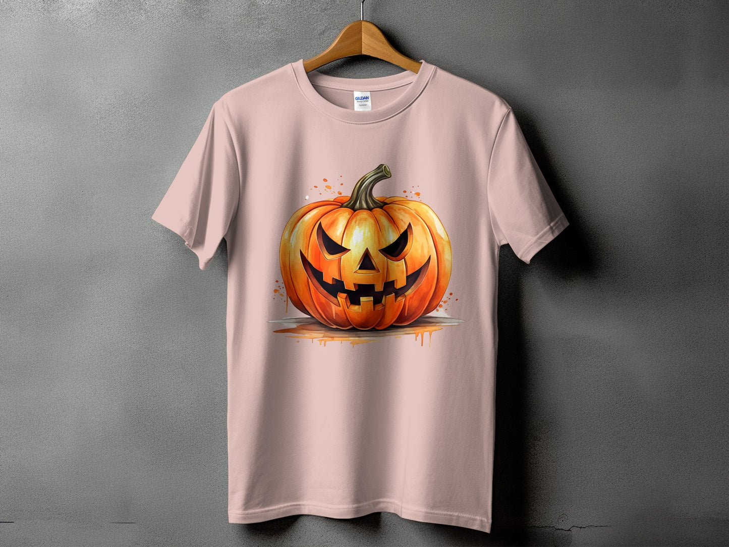 Pink t-shirt with a watercolor illustration of a spooky jack-o'-lantern.