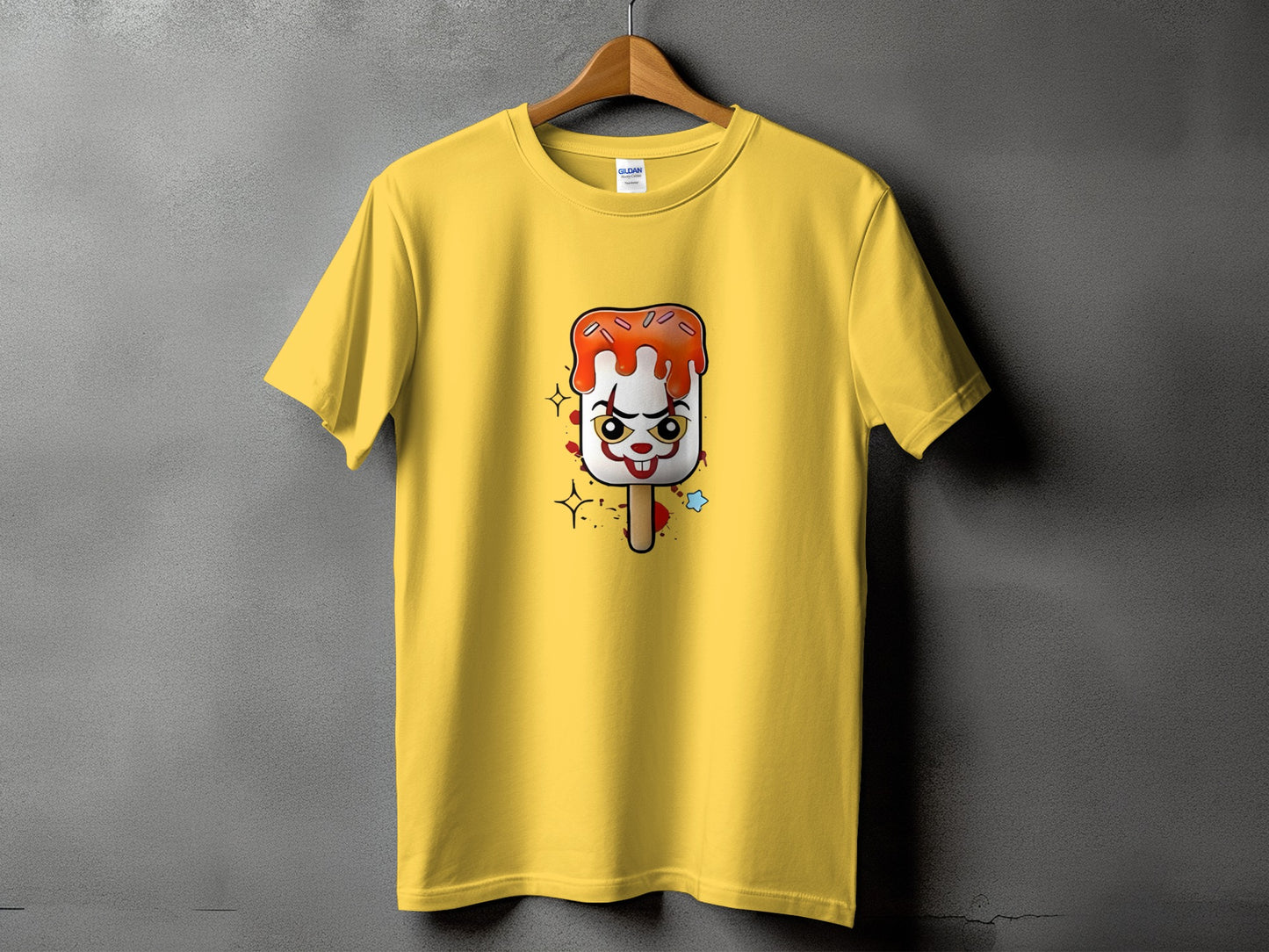 Yellow t-shirt with a creepy clown popsicle graphic and sparkles.