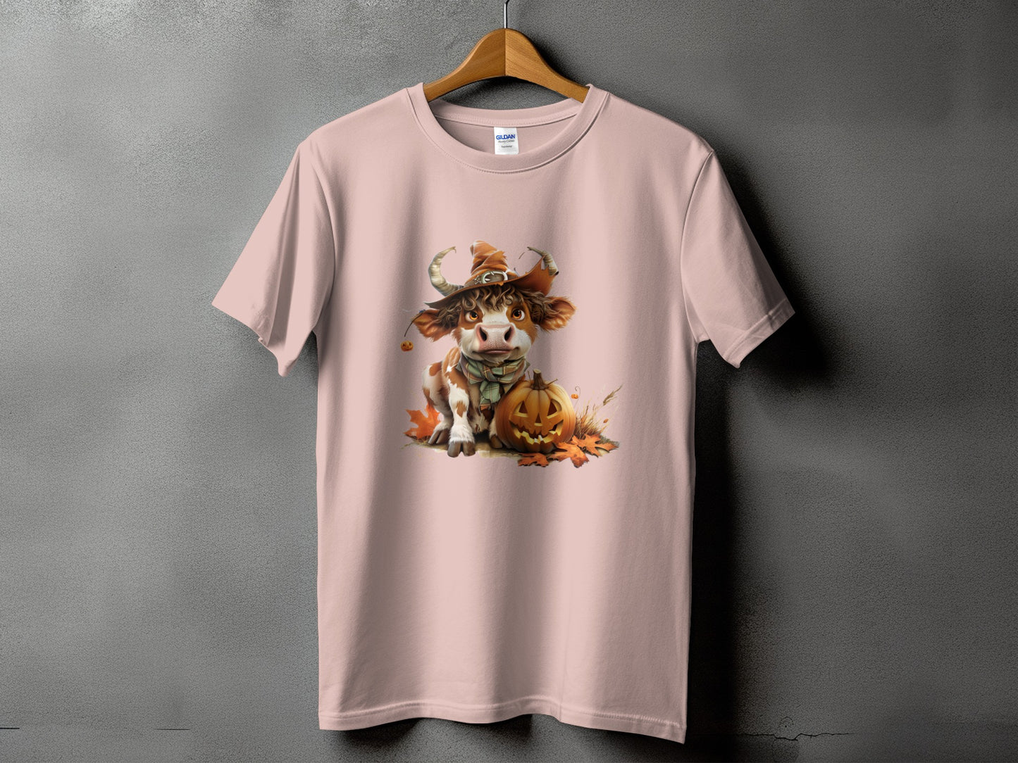 Pink t-shirt with a Halloween cow illustration and a jack-o'-lantern.