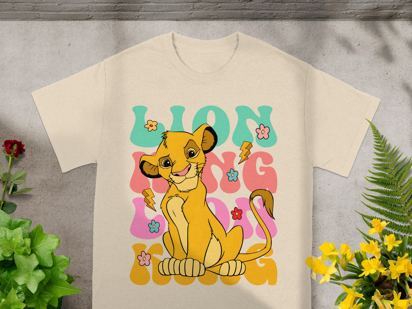Lion King Simba character with "LION KING" text and colorful graphics on t-shirt.