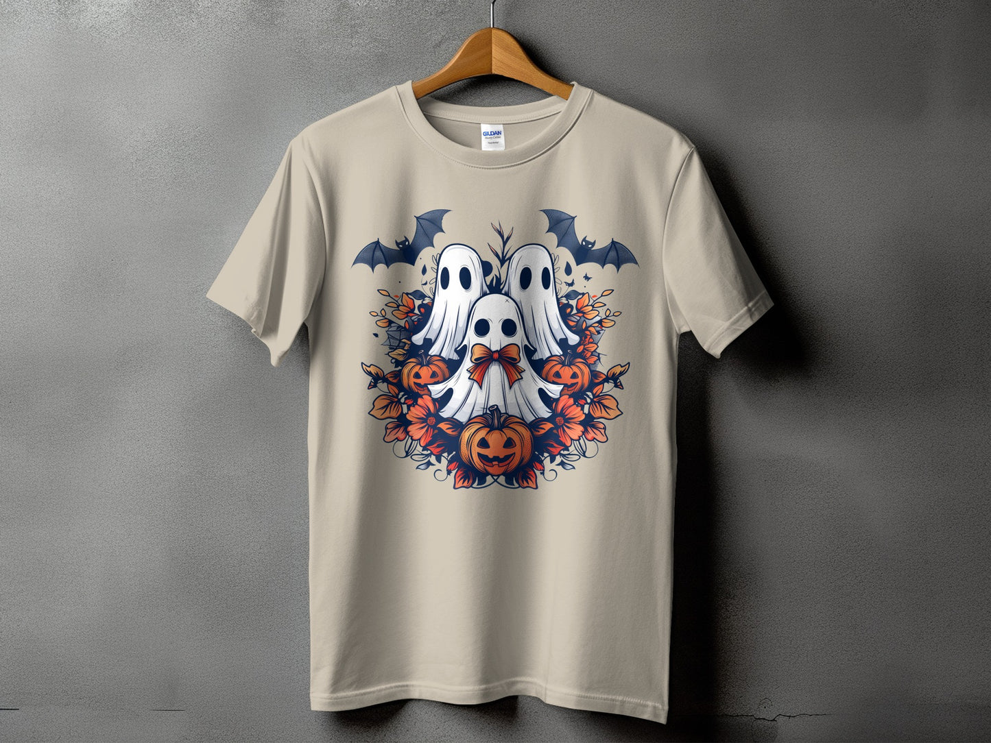Tan t-shirt with Halloween ghosts, pumpkins, bats, and flowers graphic.