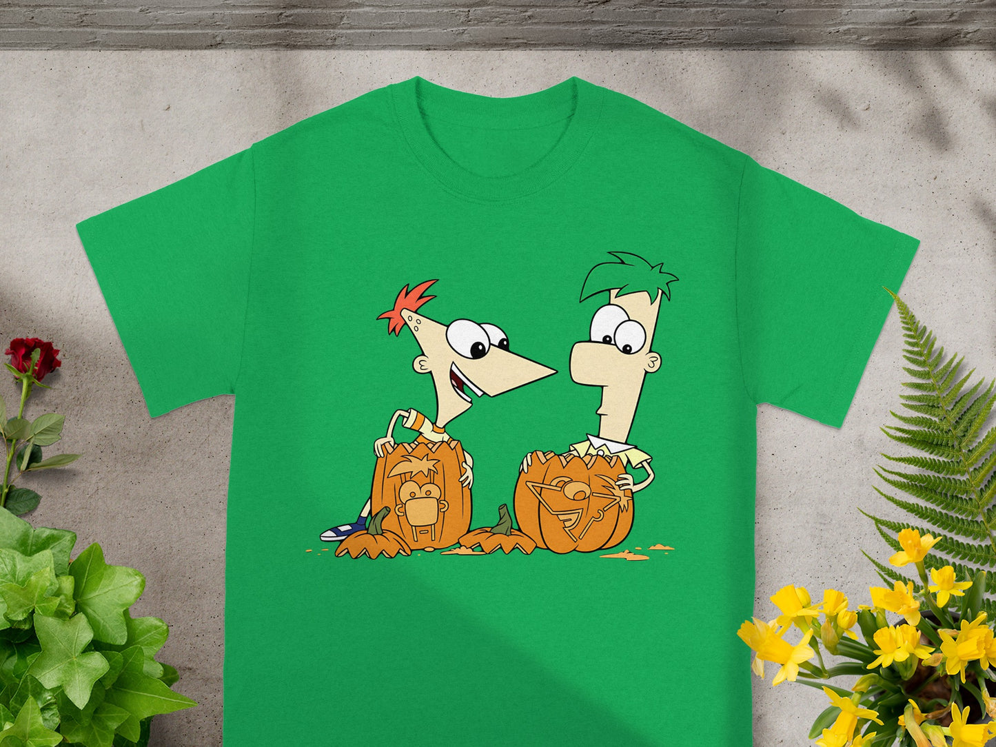 Phineas and Ferb characters carving jack-o'-lanterns on a green t-shirt.