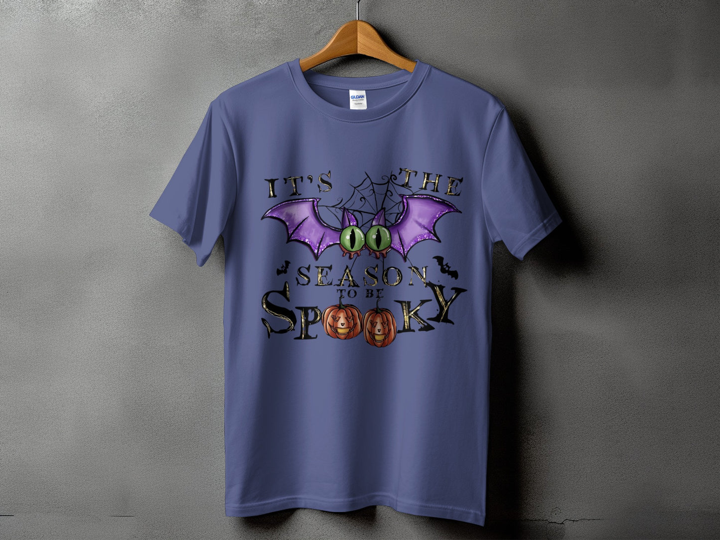 Purple t-shirt with "It's the season to be spooky" Halloween graphic.