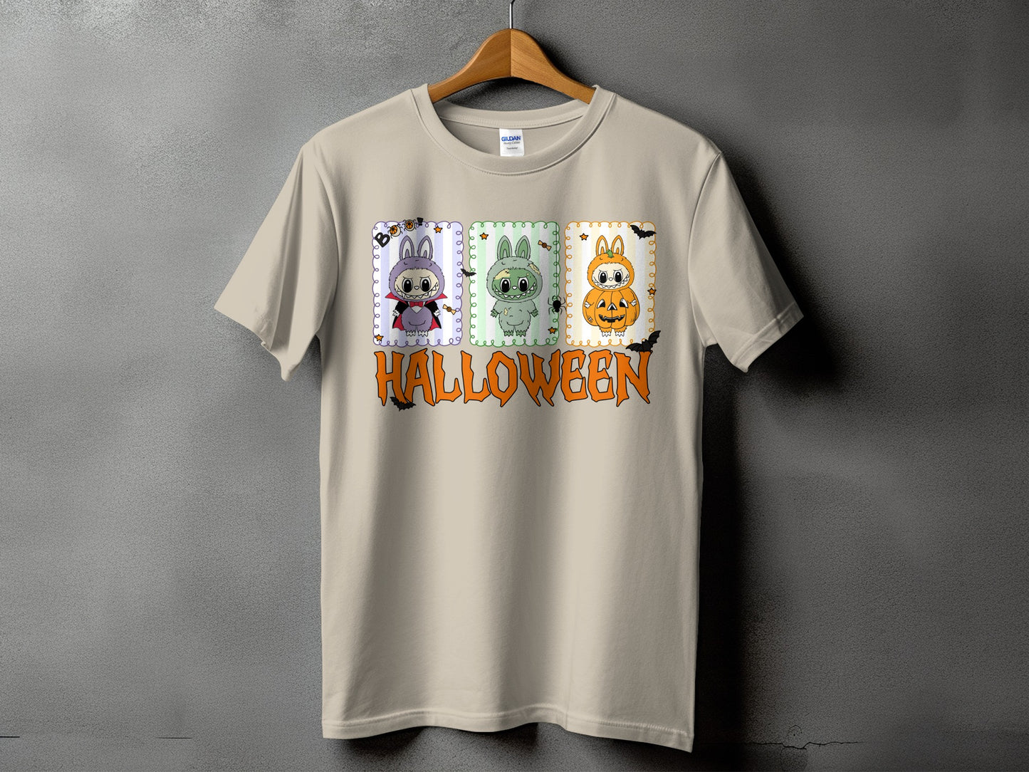 Tan t-shirt with three cartoon Halloween characters and the word HALLOWEEN.
