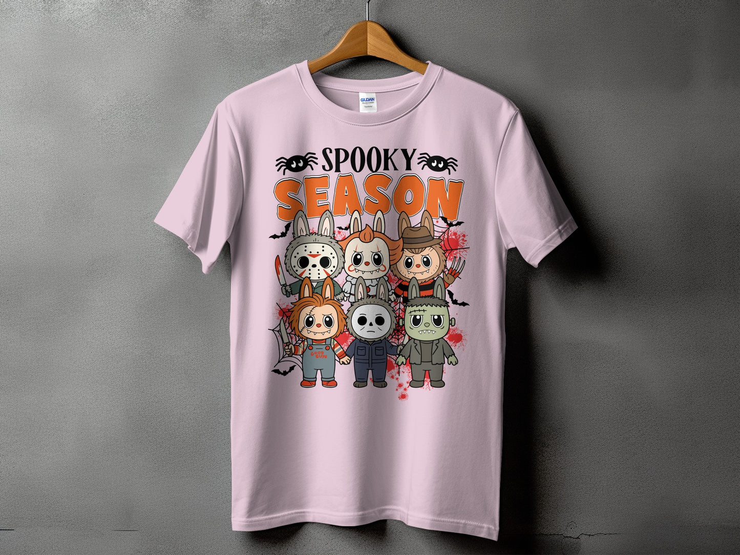 Pink t-shirt with "Spooky Season" and horror movie characters in a cartoon style.