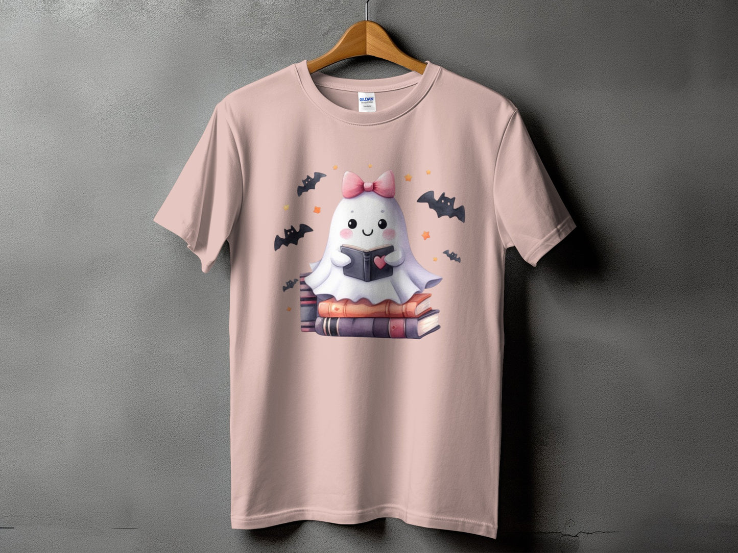 Pink t-shirt with a cute ghost reading a book surrounded by bats.