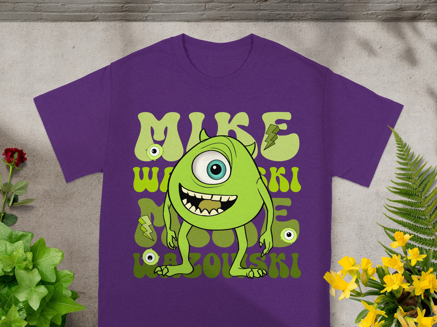 Purple t-shirt with cartoon green monster "Mike Wazowski" graphic.