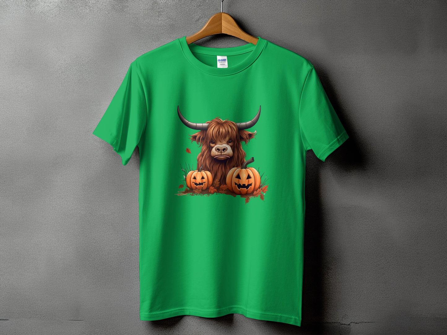 Green t-shirt with a Highland cow and two jack-o'-lanterns graphic.