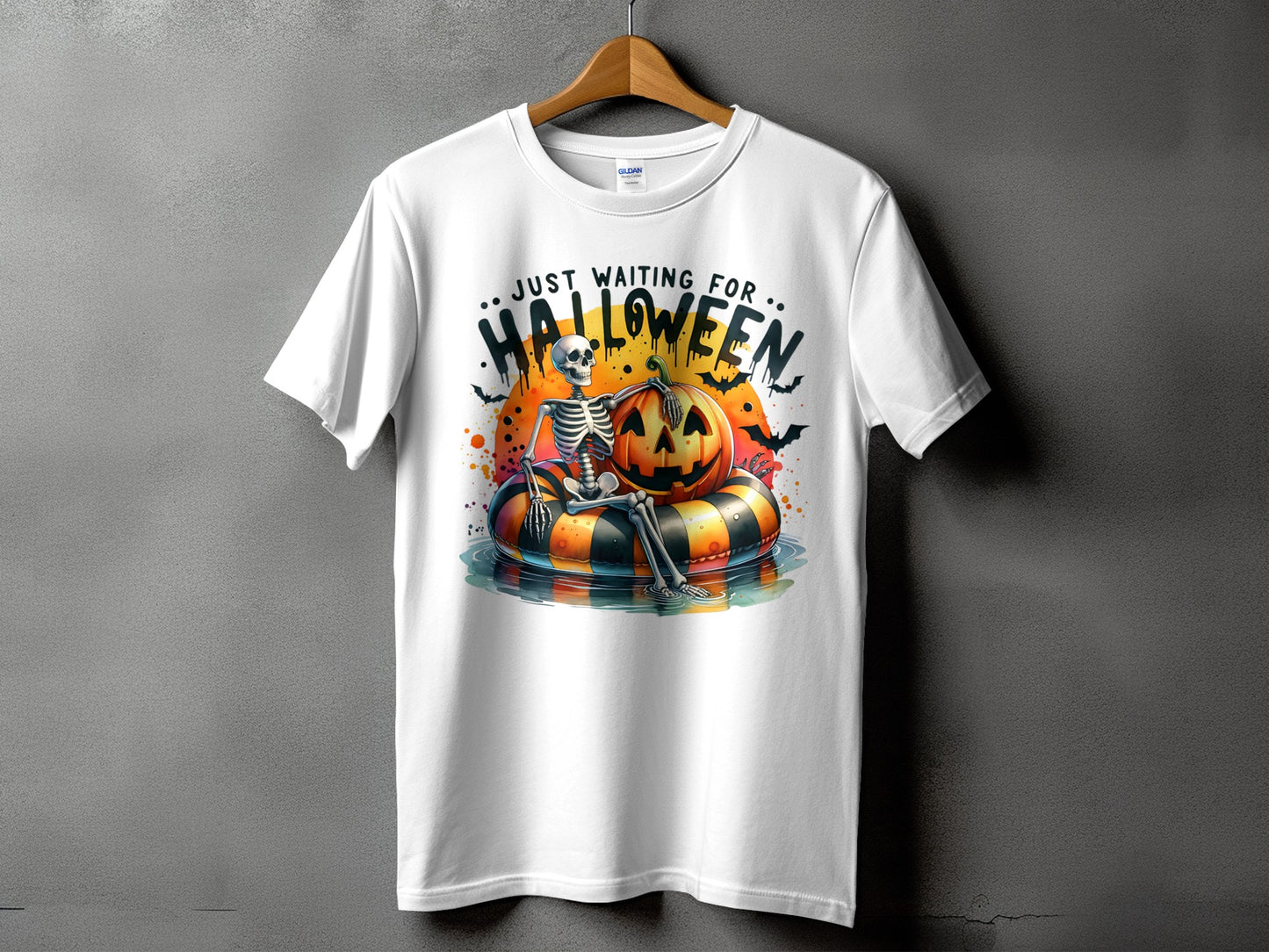 White t-shirt with skeleton, pumpkin, and bats graphic that says "Just Waiting For Halloween".