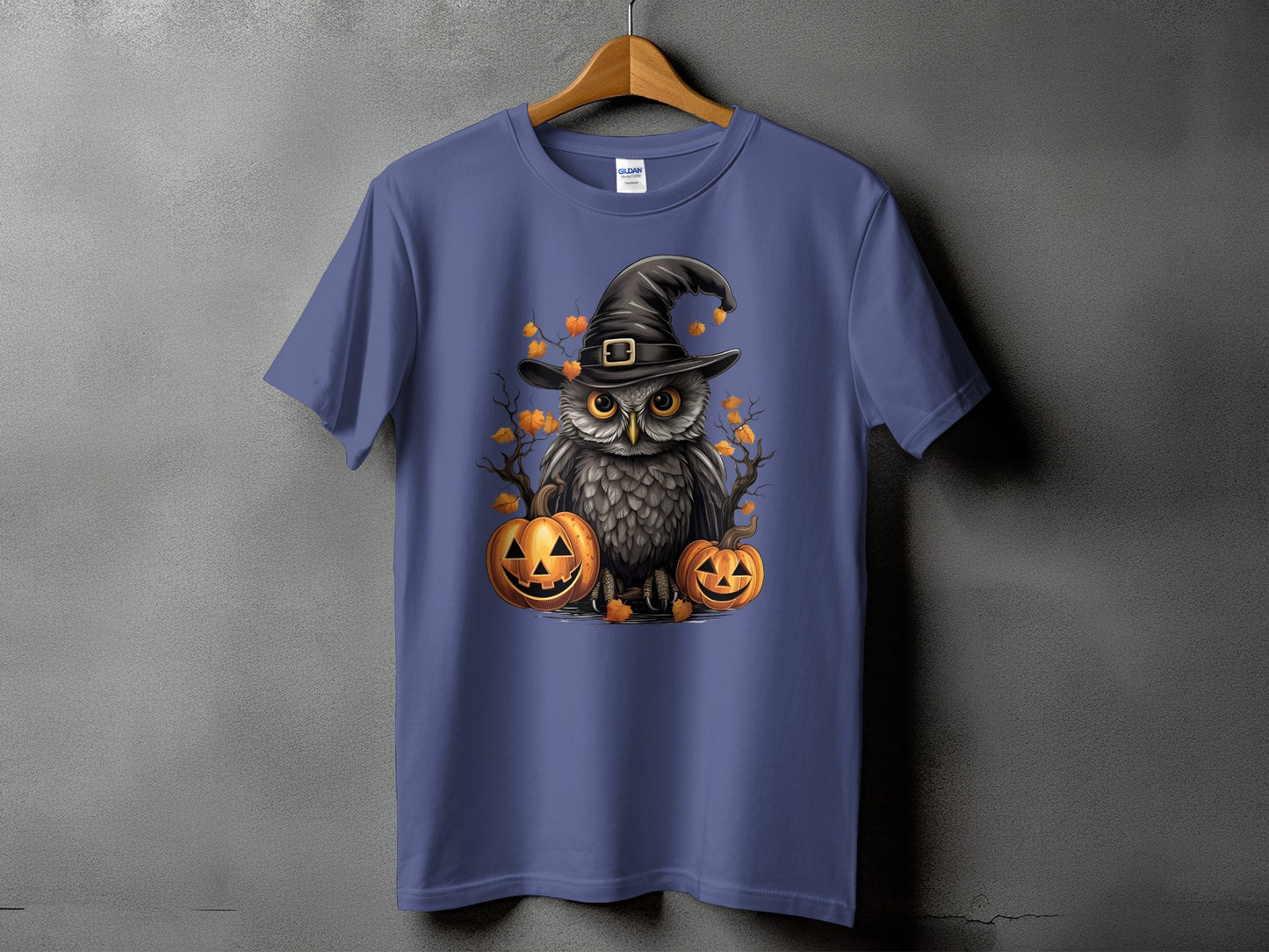 Owl in witch hat with pumpkins and autumn leaves graphic on a purple t-shirt.