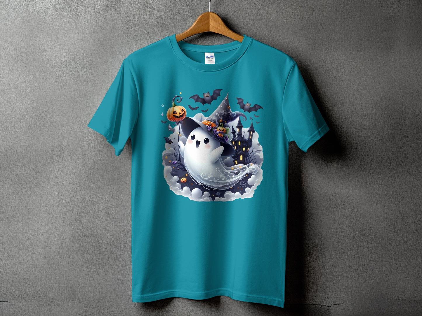 Turquoise t-shirt with a cartoon ghost wearing a witch hat and holding a pumpkin.