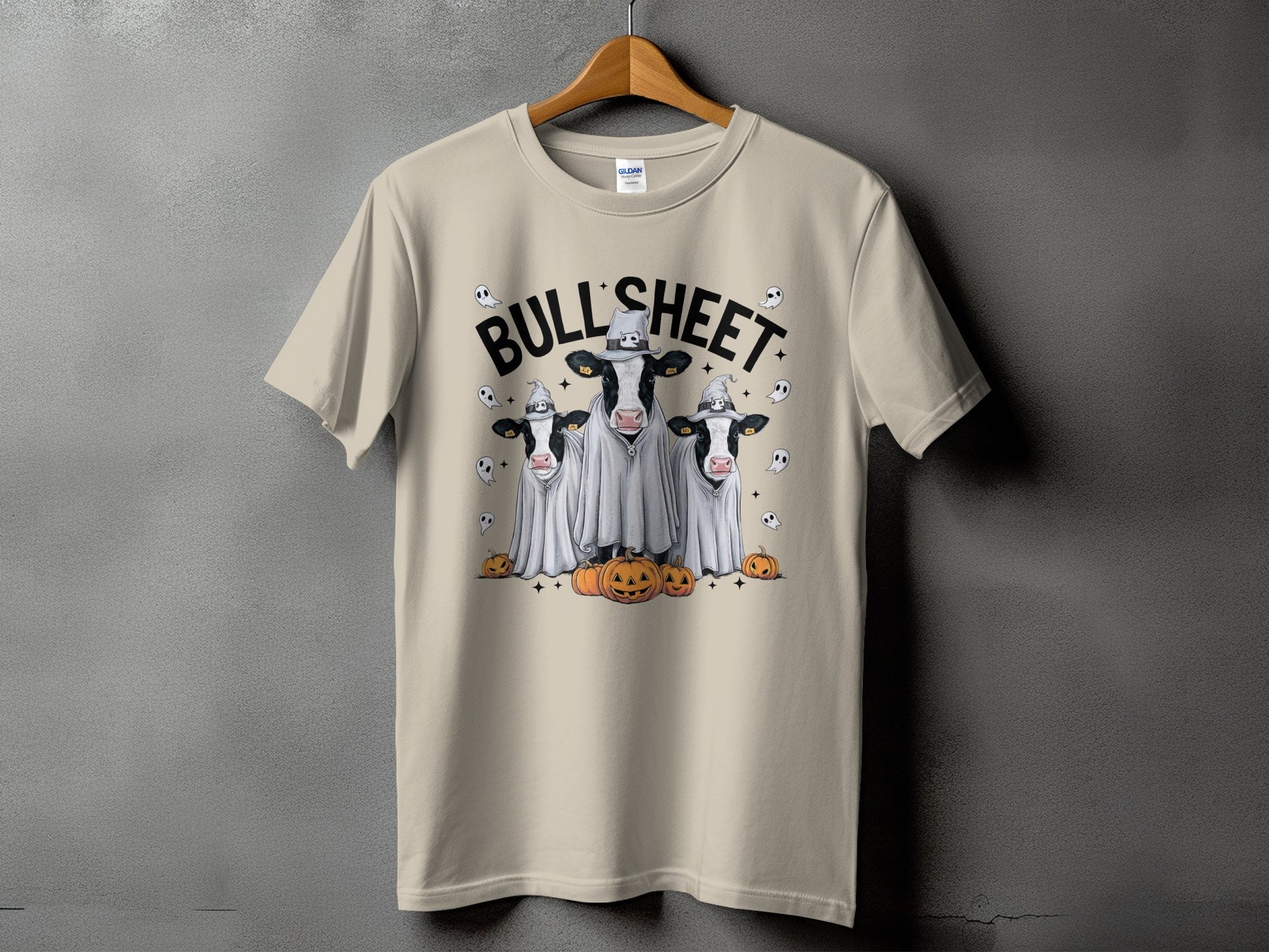 Three cows in ghost costumes with pumpkins and text "BULL'SHEET".
