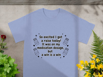 Light blue t-shirt with text about a raise and medication dosage.