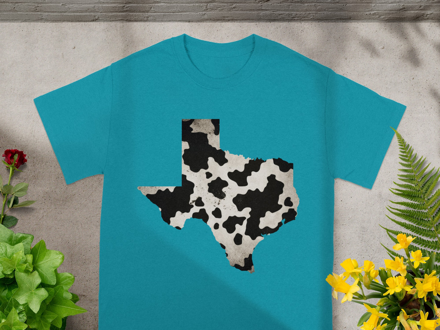 Teal t-shirt with Texas outline in cow print pattern.