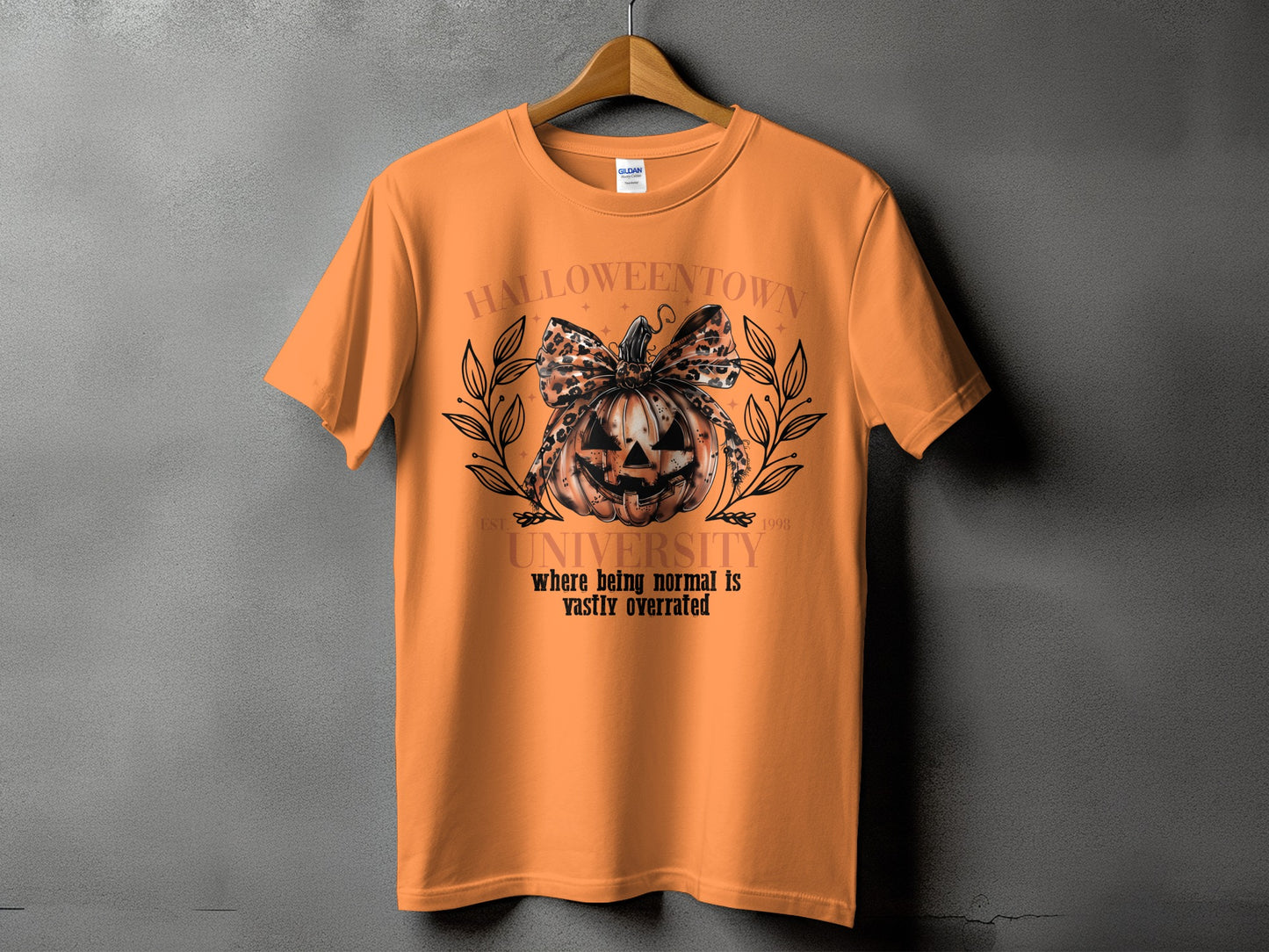 Orange t-shirt with "Halloweentown University where being normal is vastly overrated" text and pumpkin graphic.