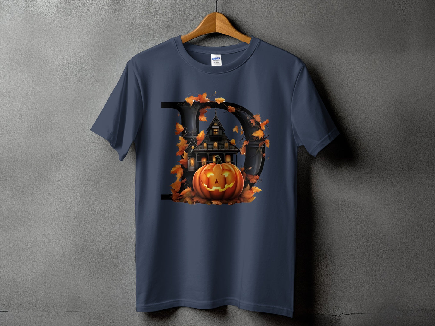 Dark blue t-shirt with a black letter D, spooky house, pumpkin, and autumn leaves graphic.