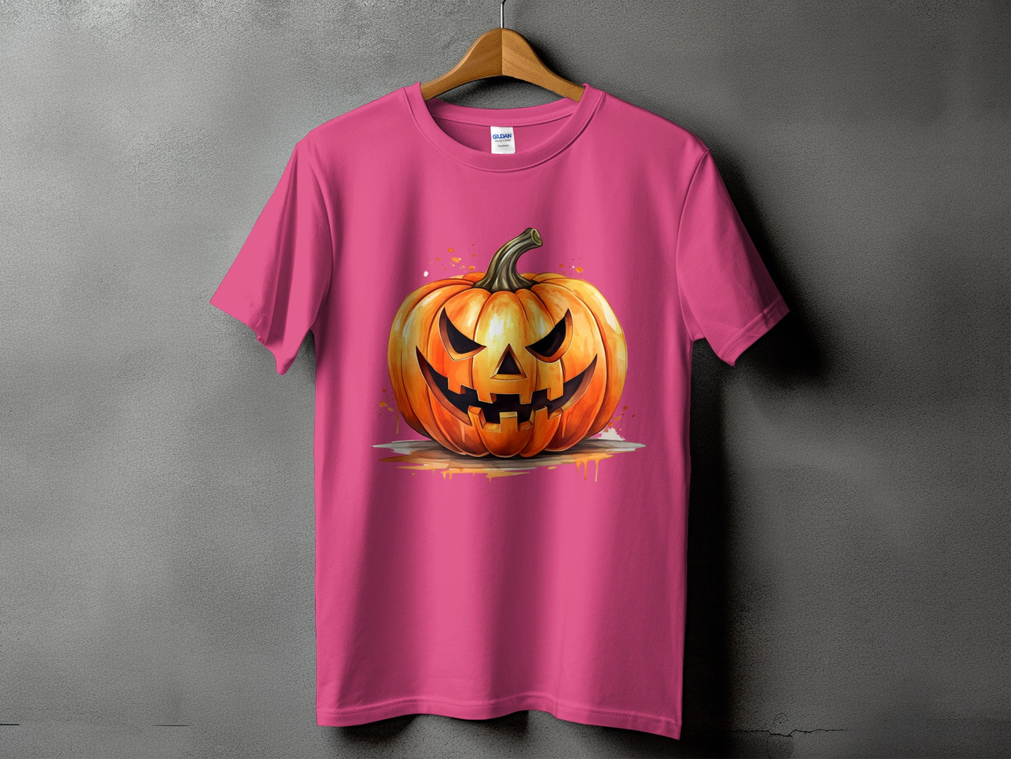 Pink t-shirt with a carved Halloween pumpkin design and watercolor splatters.
