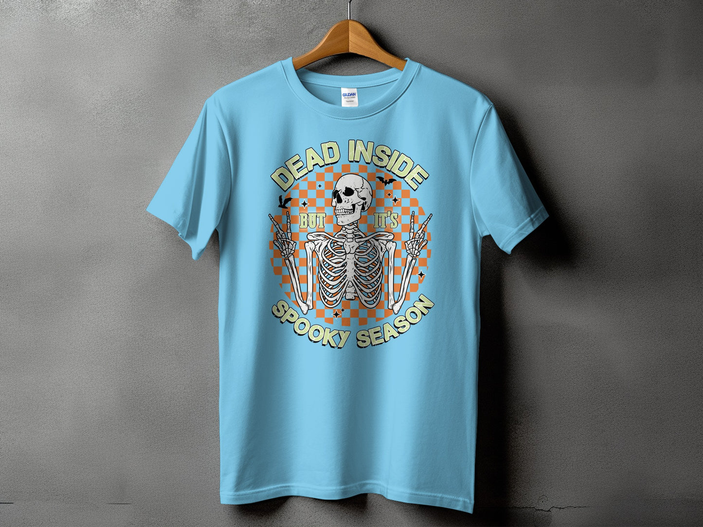 Light blue t-shirt with skeleton graphic and text "DEAD INSIDE BUT IT'S SPOOKY SEASON".