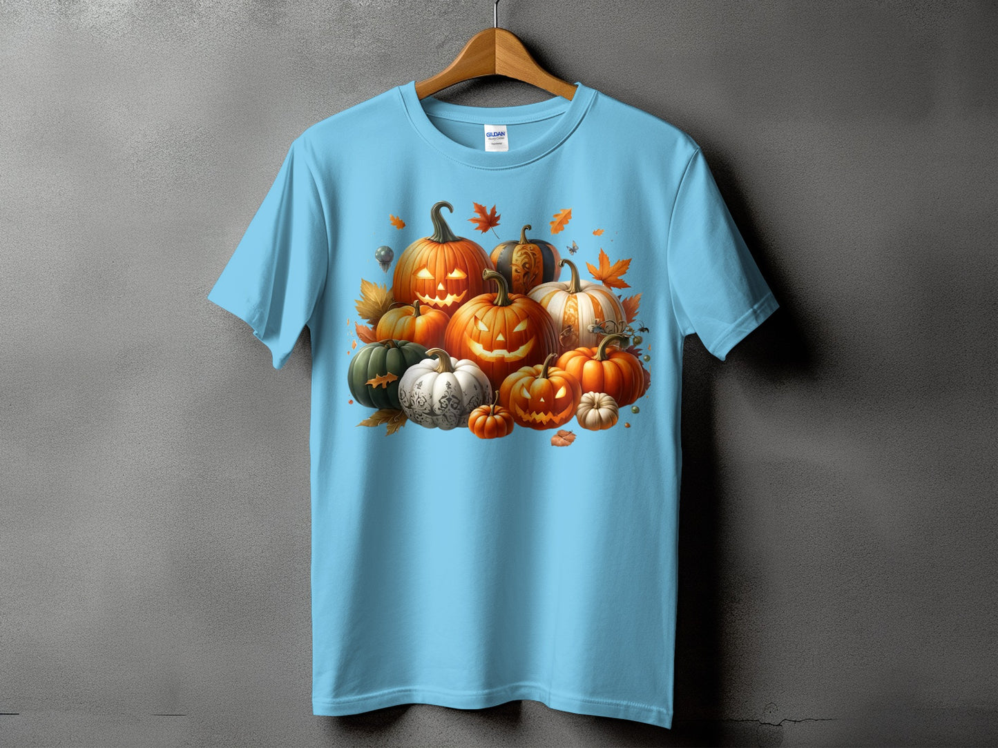 Light blue t-shirt with various carved and uncarved pumpkins and autumn leaves.