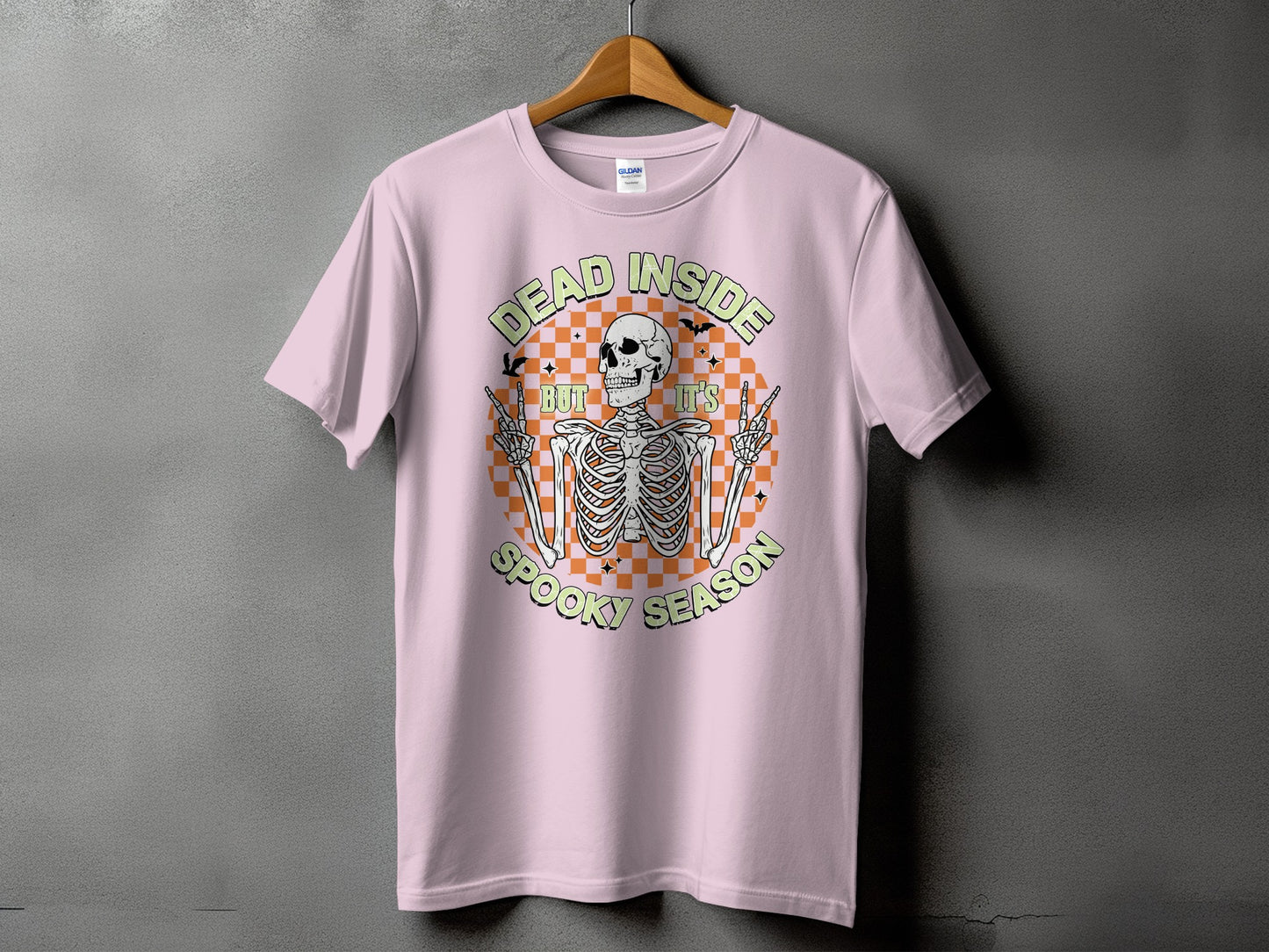 Pink t-shirt with a skeleton graphic and text "DEAD INSIDE BUT IT'S SPOOKY SEASON."
