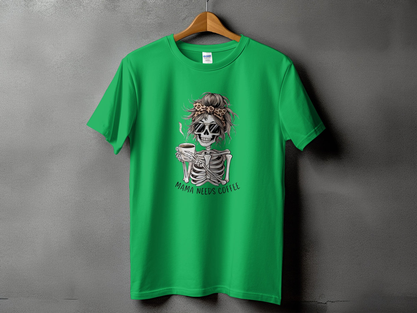 Green t-shirt with skeleton graphic holding coffee and text "MAMA NEEDS COFFEE".