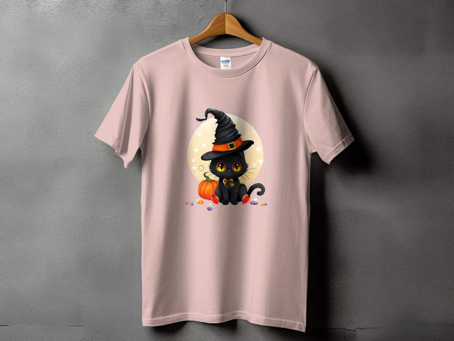 Pink t-shirt with a black cat wearing a witch hat and sitting with a pumpkin.